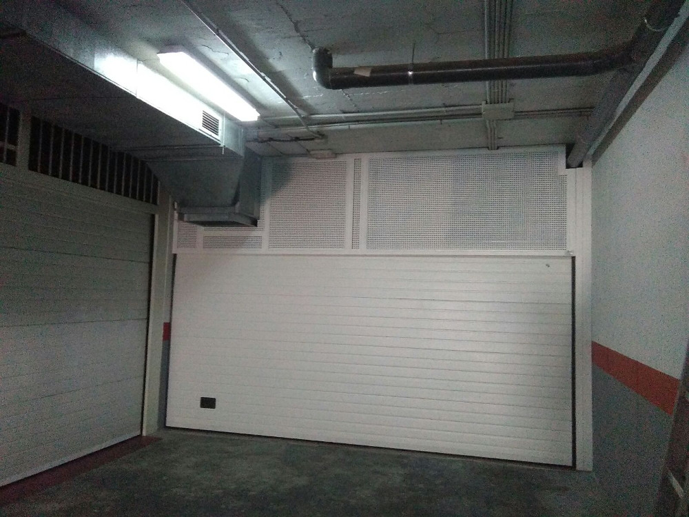 Puerta seccional exterior con rejilla de ventilación