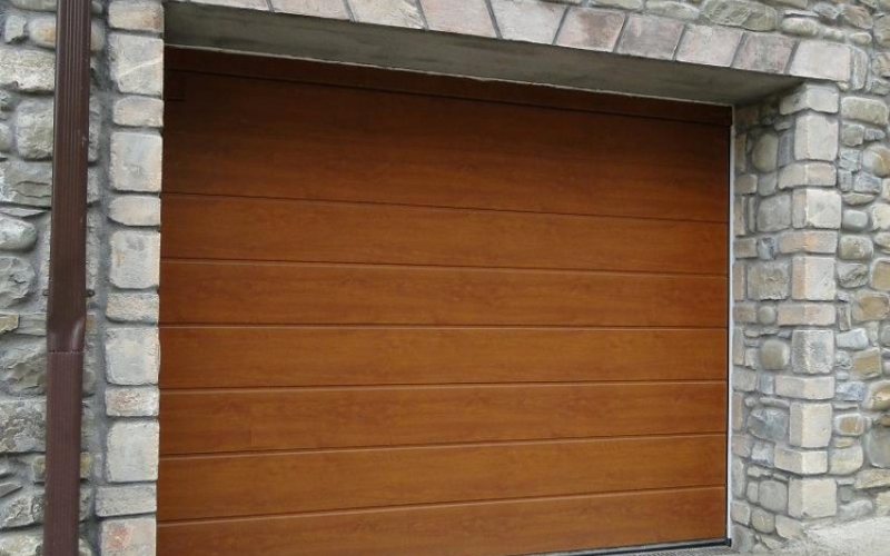 Puerta seccional de apertura vertical y acabado en madera