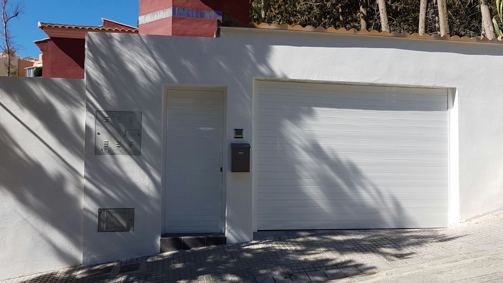Puerta de garaje seccional y puerta peatonal con paneles